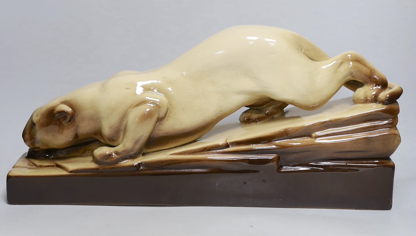 An Art Deco French pottery figure of a stalking panther, 53cm long